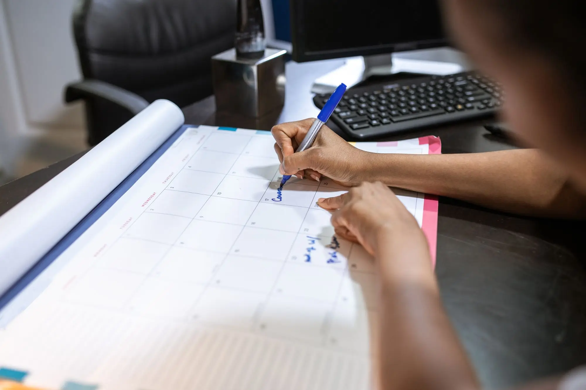 Business owner marking the date a fixed-rate home loan period ends on a desk planner in her office